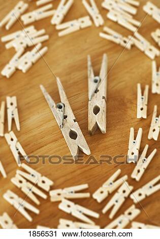 Stock Image - Two large clothespins surrounded by smaller ones. Fotosearch