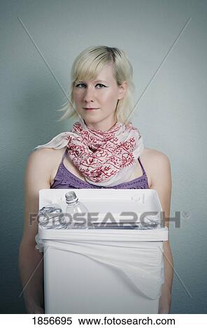 Stock Photography - Woman holding bottles in a garbage. Fotosearch