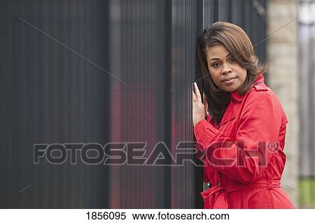 Stock Photography - Woman leaning against fence. Fotosearch