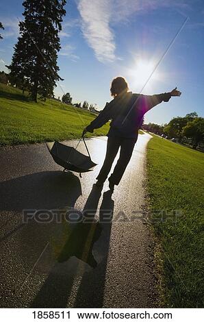 Woman playing in the rain puddles View Large Photo Image Stock Image - Woman playing in the rain puddles. Fotosearch