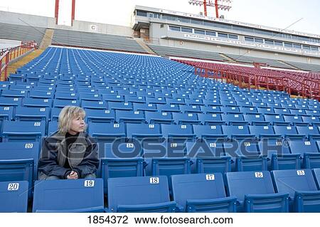 Woman sitting alone in stadium seats View Large Photo Image Stock Image - Woman sitting alone in stadium seats. Fotosearch