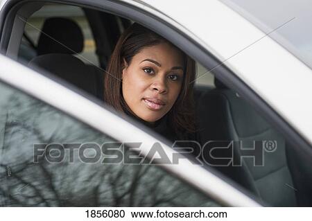 Woman sitting in a vehicle with the door open View Large Photo Image Stock Image - Woman sitting in a vehicle with the door open. Fotosearch