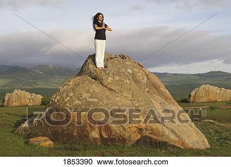 Woman standing on a rock and meditating View Large Photo Image Stock Image - Woman standing on a rock and meditating. Fotosearch