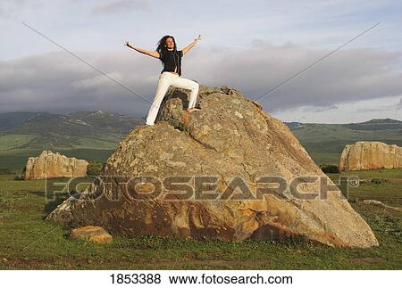 Woman stretching on a rock View Large Photo Image Stock Photo - Woman stretching on a rock. Fotosearch