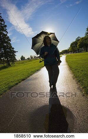Woman with an umbrella; St. Albert, Alberta, Canada View Large Photo Image Stock Image - Woman with an umbrella; St. Albert, Alberta, Canada. Fotosearch