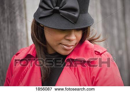 Stock Photo - Woman with black had and red coat. Fotosearch
