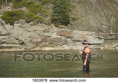 Stock Photo - Young boy fly fishing in a river, Nordegg, Alberta, Canada. Fotosearch