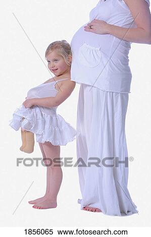 Young girl mimicking her mother's pregnancy View Large Photo Image Stock Photography - Young girl mimicking her mother's pregnancy. Fotosearch