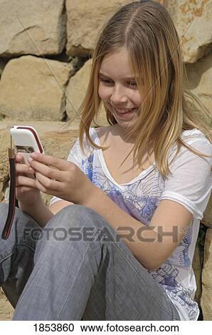 Young girl using cell phone View Large Photo Image Stock Image - Young girl using cell phone. Fotosearch