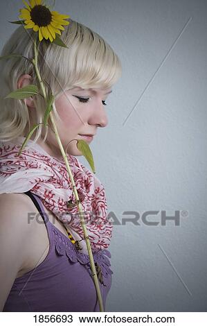 Young woman with a sunflower View Large Photo Image Stock Image - Young woman with a sunflower. Fotosearch
