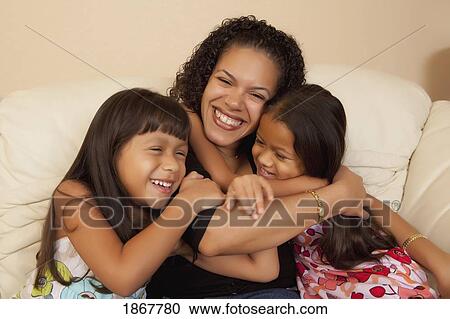 Stock Image - Mother hugging her daughters. Fotosearch