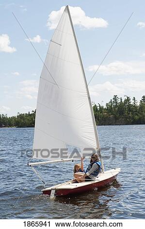 Stock Image - People in sailboat, Lake of the Woods, Ontario, Canada. Fotosearch