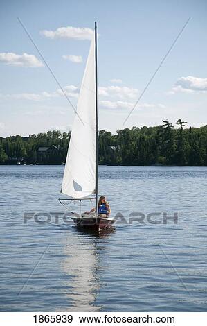 Stock Photo - Person in sailboat, Lake of the Woods, Ontario, Canada. Fotosearch