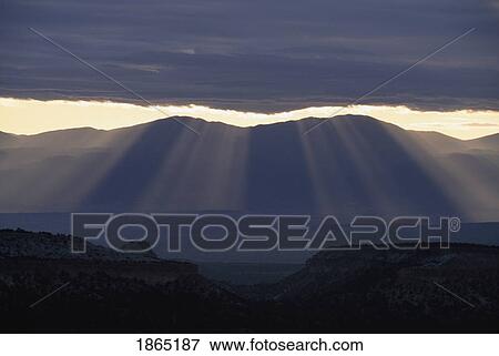 Stock Photo - Sun rays, Sangre de Cristo Mountains, with mesas and the Rio Grande Valley, New Mexico, USA. Fotosearch