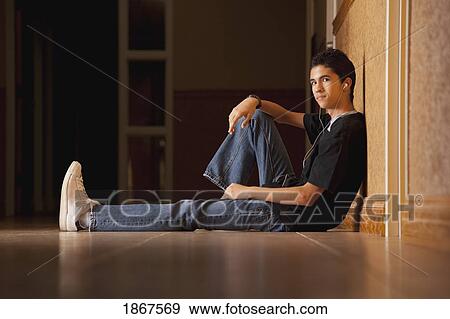 Teenage boy sitting on the floor View Large Photo Image Stock Photo - Teenage boy sitting on the floor. Fotosearch