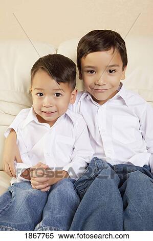 Stock Photography - Two boys sitting on a couch. Fotosearch