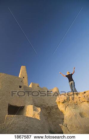 Woman tourist at The Temple of the Oracle (Temple of Amun) at the Siwa Oasis in Egypt View Large Photo Image Stock Photo - Woman tourist at The Temple of the Oracle (Temple of Amun) at the Siwa Oasis in Egypt. Fotosearch
