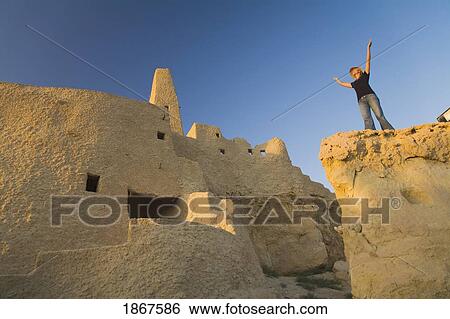 Woman tourist at The Temple of the Oracle (Temple of Amun) at the Siwa Oasis in Egypt View Large Photo Image Stock Photograph - Woman tourist at The Temple of the Oracle (Temple of Amun) at the Siwa Oasis in Egypt. Fotosearch