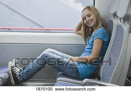 a girl sitting on a seat on a train View Large Photo Image Stock Image - a girl sitting on a seat on a train. Fotosearch