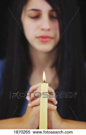 a teenage girl praying with a candle lit View Large Photo Image Stock Photography - a teenage girl praying with a candle lit. Fotosearch