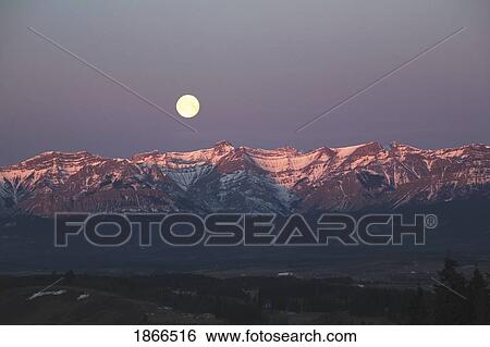 Stock Photograph - Alberta, Canada; Moon set over Front Range mountains. Fotosearch