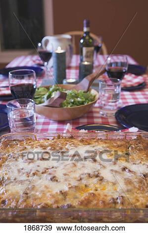 Stock Photo - baked lasagna on a table set for dinner. Fotosearch