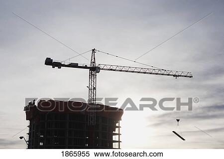 Stock Photography - Construction crane against building frame, Calgary, Alberta, Canada. Fotosearch