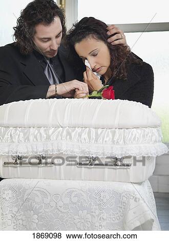 Stock Photo - couple grieving at infant's coffin. Fotosearch