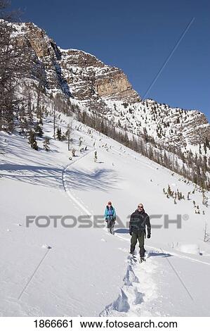 Couple on snowshoes on a mountain View Large Photo Image Stock Image - Couple on snowshoes on a mountain. Fotosearch