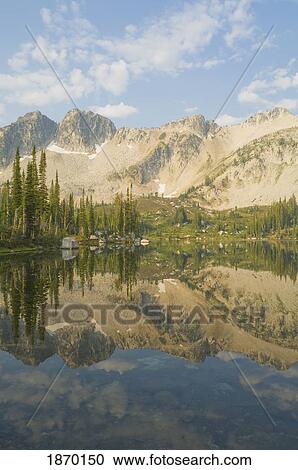 Stock Image - eagle cap wilderness, oregon, united states of america; reflection of mountains on blue lake. Fotosearch