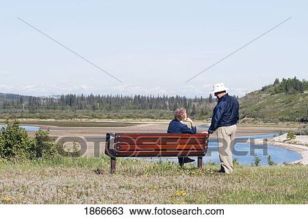 Elderly couple sitting on a bench View Large Photo Image Stock Image - Elderly couple sitting on a bench. Fotosearch