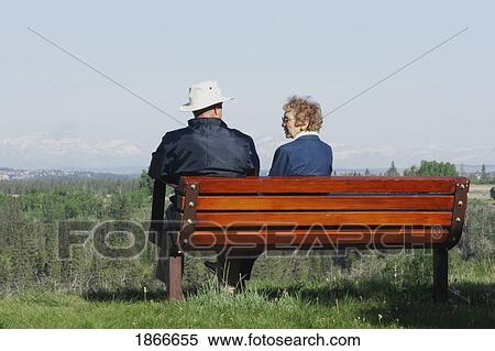 Stock Photography - Elderly couple sitting on a bench. Fotosearch