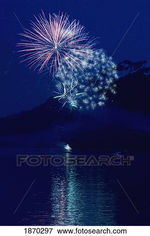 fireworks over the water with a mountain in the background View Large Photo Image Stock Photo - fireworks over the water with a mountain in the background. Fotosearch