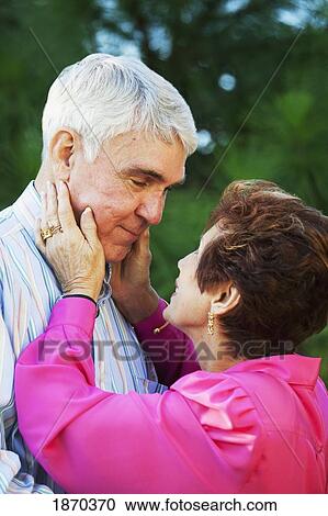 Stock Image - fort lauderdale, florida, united states of america; a couple with the woman holding the man's face in her hands. Fotosearch