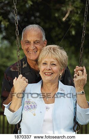 Stock Photo - fort lauderdale, florida, united states of america; a couple with the woman sitting on a swing. Fotosearch