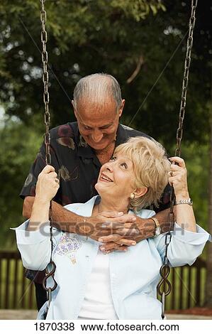 Stock Photo - fort lauderdale, florida, united states of america; a couple with the woman sitting on a swing. Fotosearch