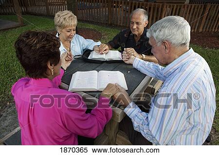 Stock Photography - fort lauderdale, florida, united states of america; two couples praying together with their bibles open. Fotosearch