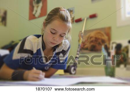 Stock Photo - girl doing homework on the floor. Fotosearch
