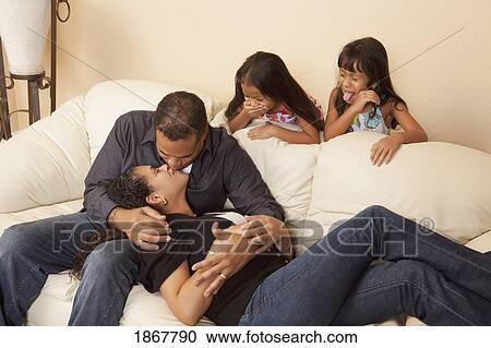 Stock Image - girls watching their parents kissing. Fotosearch