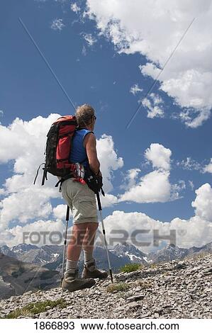 Man on a mountain looking at the view View Large Photo Image Stock Image - Man on a mountain looking at the view. Fotosearch