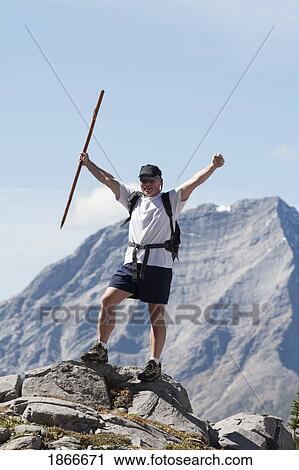 Stock Image - Man on the top of a mountain. Fotosearch