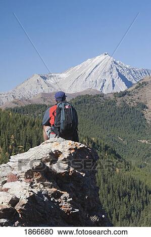 Man sitting on the top of a mountain View Large Photo Image Stock Image - Man sitting on the top of a mountain. Fotosearch
