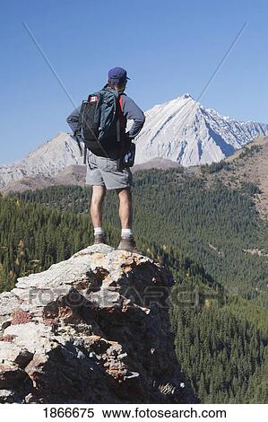 Man standing on the top of a mountain View Large Photo Image Stock Photography - Man standing on the top of a mountain. Fotosearch