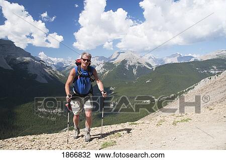 Man walking on a mountain trail View Large Photo Image Stock Image - Man walking on a mountain trail. Fotosearch
