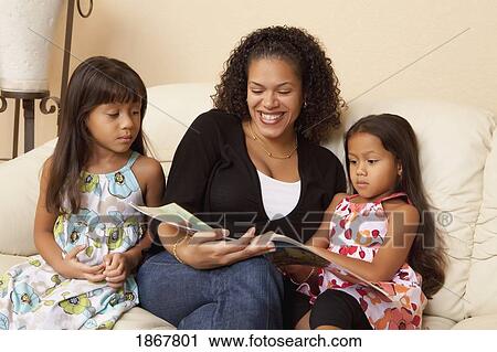 Stock Image - mother reading to her daughters. Fotosearch