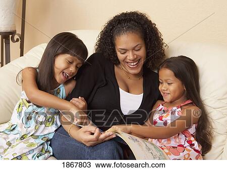 Stock Image - mother reading to her daughters. Fotosearch