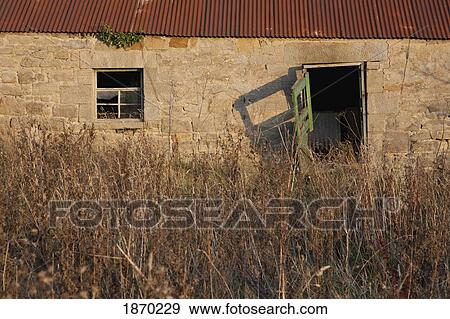 Stock Photo - northumberland, england; an old building with tall grass. Fotosearch