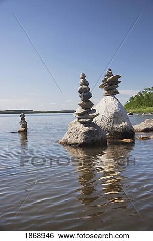 piles of rocks in the shallow water along the shore View Large Photo Image Stock Photograph - piles of rocks in the shallow water along the shore. Fotosearch