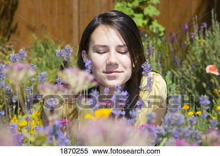 Stock Photography - portrait of a girl smelling wildflowers. Fotosearch