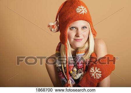Stock Image - portrait of a young woman in a toque, mittens and scarf. Fotosearch